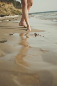 Walking barefoot along a beach on holiday
